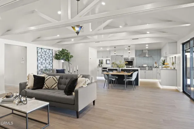 a living room with furniture and view of kitchen
