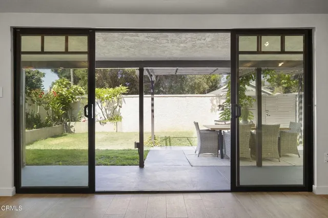 a view of a glass door with a floor to ceiling window next to a yard