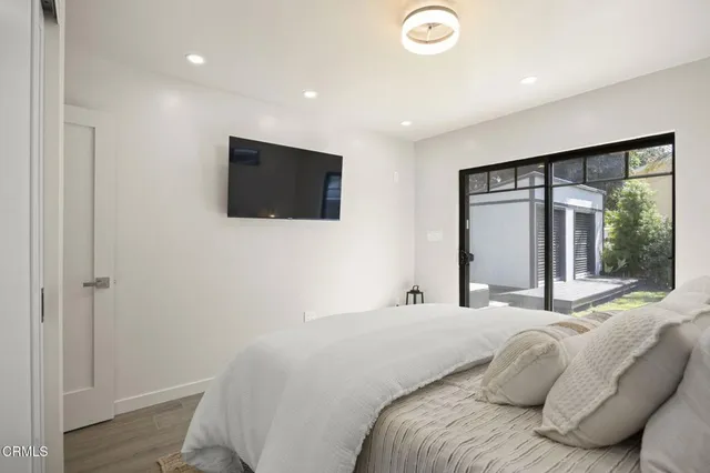 a bedroom with a large bed and a flat screen tv