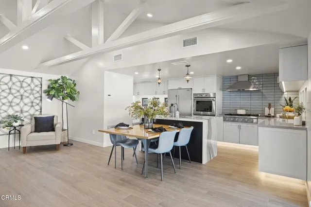 a dining room with furniture and kitchen view