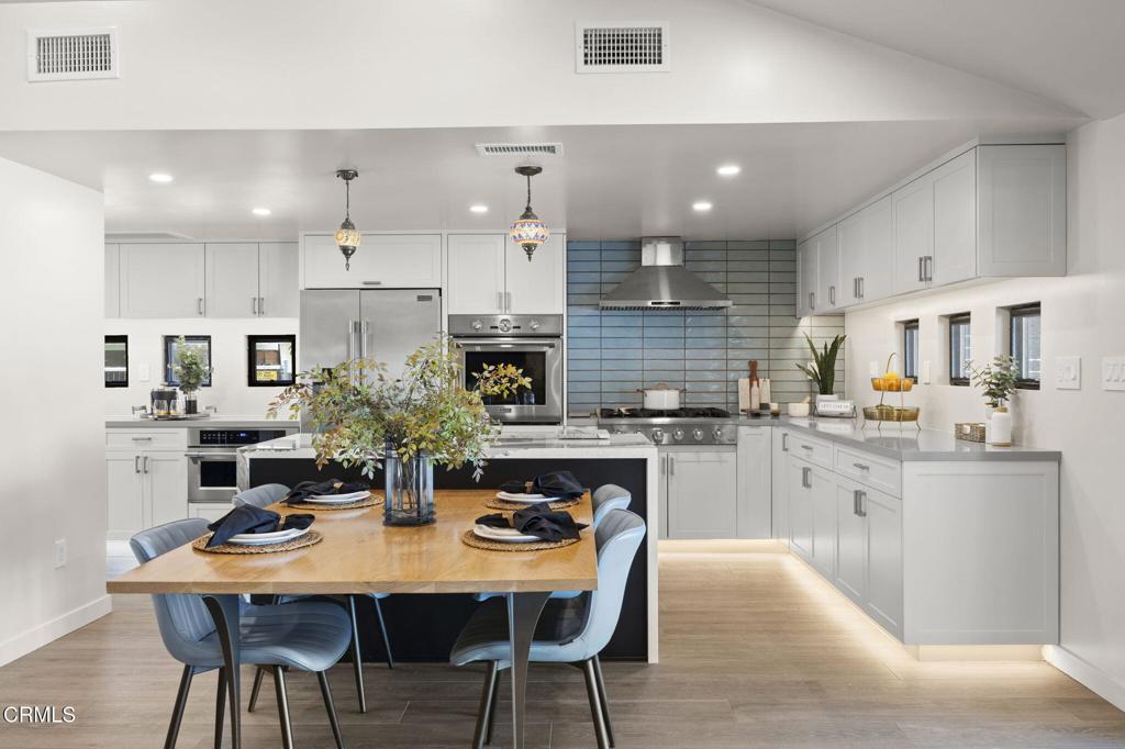 240 North Padre Juan Avenue Ojai, CA 93023 - Photo 4 of 50 a kitchen with stainless steel appliances kitchen island granite countertop a dining table chairs and white cabinets