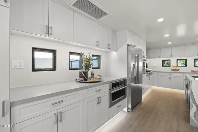 a kitchen with white cabinets and stainless steel appliances