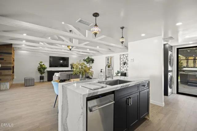 a kitchen with a sink a counter top space stainless steel appliances and a center island
