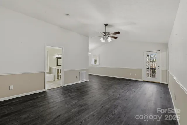 a view of a room with wooden floor and ceiling fan