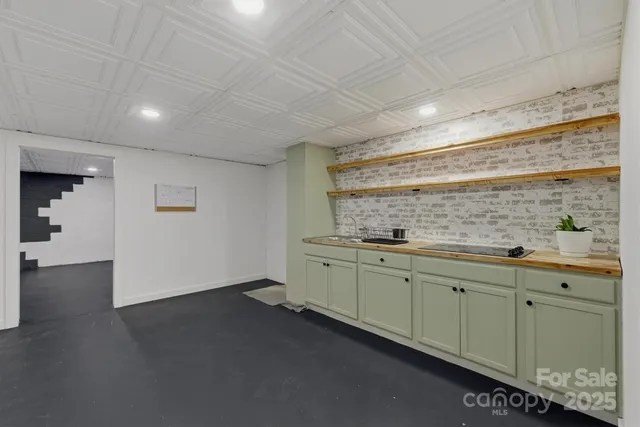 a room with granite countertop lots of wooden cabinets and sink