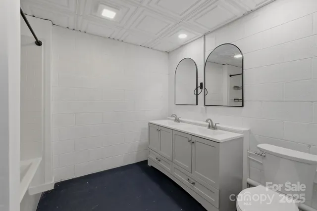 a bathroom with a sink and mirror with toilet