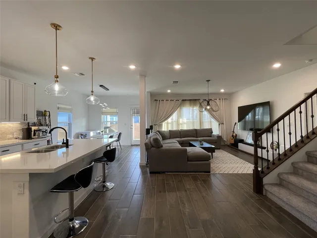 a bedroom with a bed rug dresser and a flat tv screen