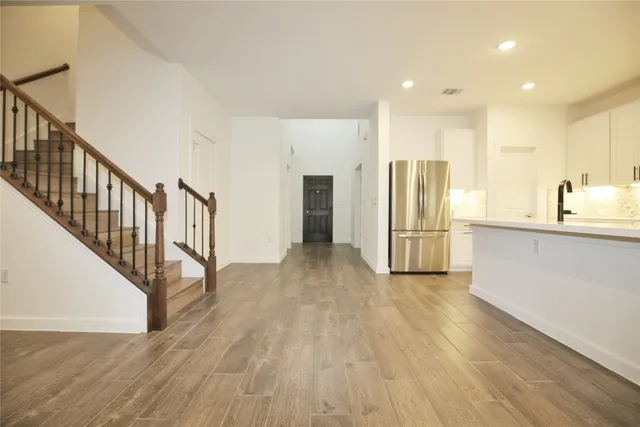a kitchen with granite countertop a refrigerator stove top oven and cabinets