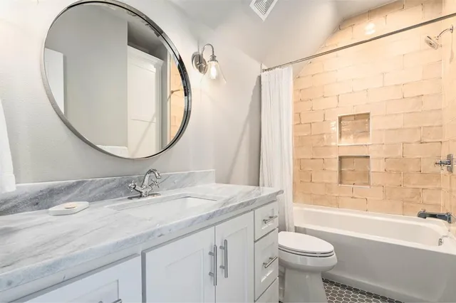 a bathroom with a toilet sink vanity and mirror