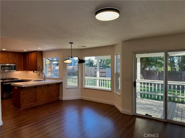 a kitchen with stainless steel appliances granite countertop a stove a sink and a large window