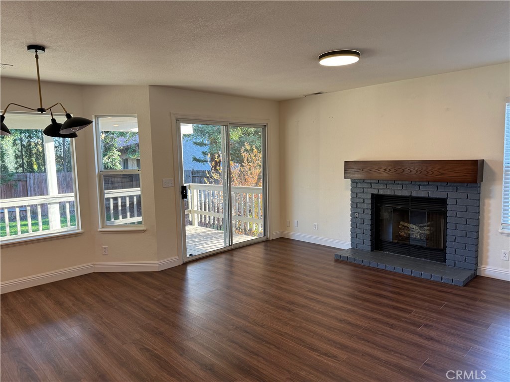 2673 Lakewest Drive Chico, CA 95928 - Photo 7 of 26 a view of an empty room with wooden floor fireplace and a window