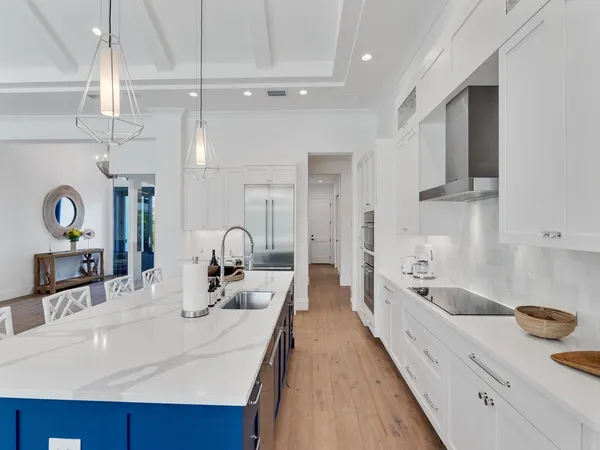 a large white kitchen with a sink and cabinets