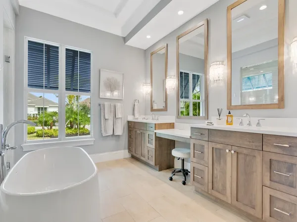 a large white kitchen with a large window and stainless steel appliances