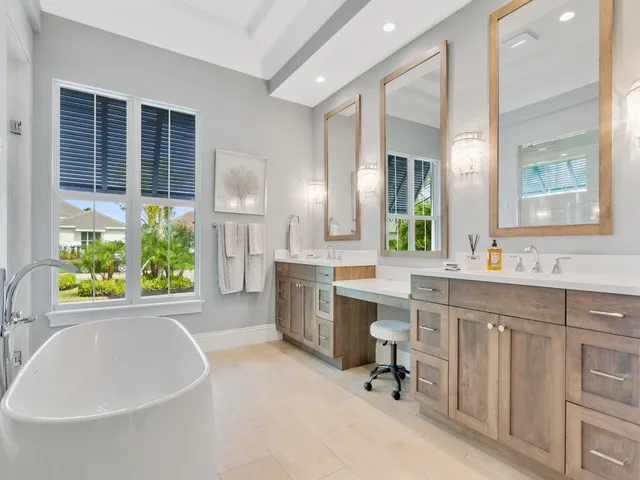 a large white kitchen with a large window and stainless steel appliances