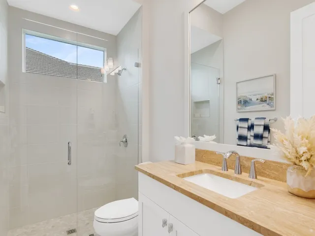 a bathroom with a granite countertop sink a toilet and shower