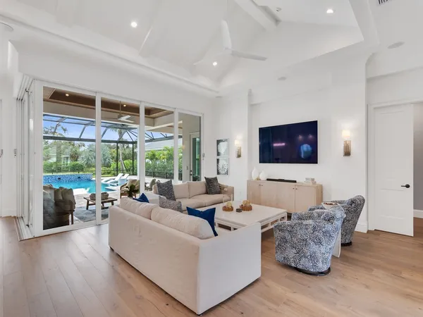 a living room with furniture wooden floor and a large window