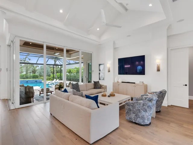 a living room with furniture wooden floor and a large window