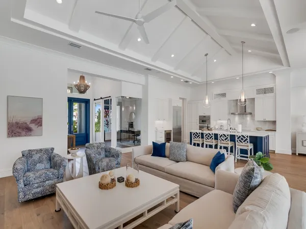 a living room with furniture and a view of kitchen