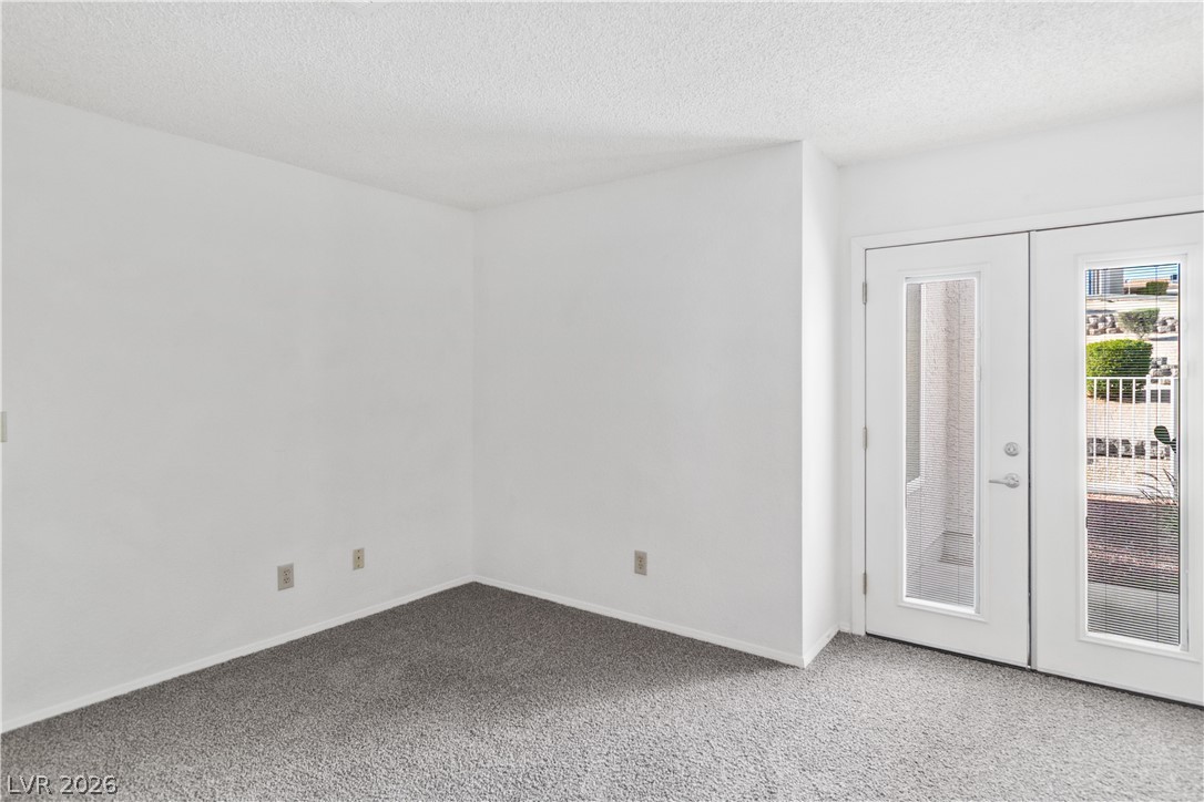 2146 High Dunes Lane Laughlin, NV 89029 - Photo 23 of 64 Primary bedroom featuring a textured ceiling, french doors, and carpet floors