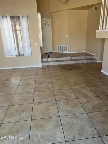 a view of a livingroom with an empty space and a window