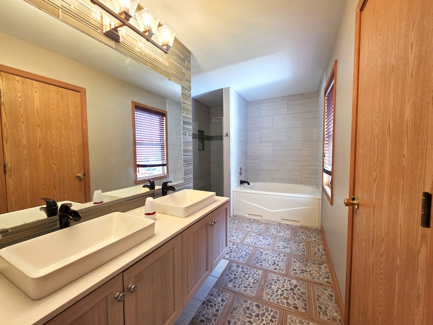 2513 Ridgefield Drive Belvidere, IL 61008 - Photo 18 of 35 a bathroom with a double vanity sink a mirror and a bathtub