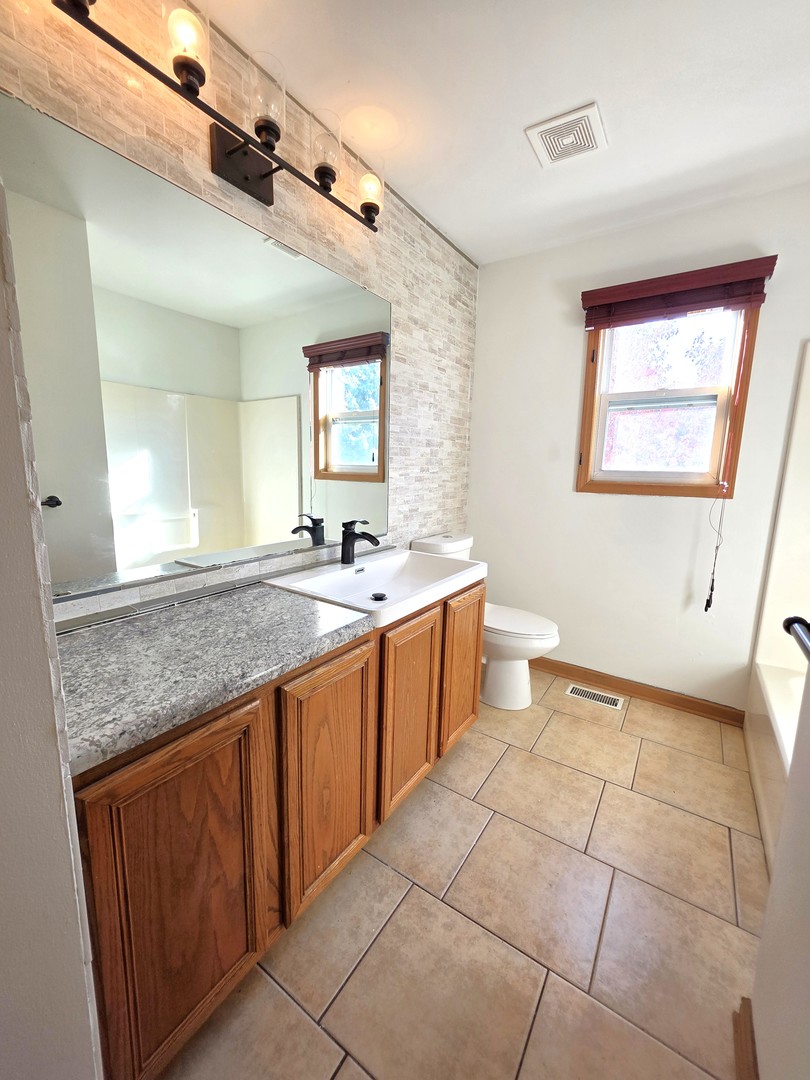 2513 Ridgefield Drive Belvidere, IL 61008 - Photo 24 of 35 a large bathroom with a granite countertop sink and a mirror