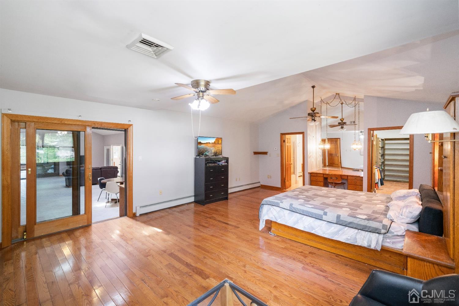 109 Fresh Ponds Road Monroe Township, NJ 08831 - Photo 32 of 83 a spacious bedroom with a large bed a chandelier and closet