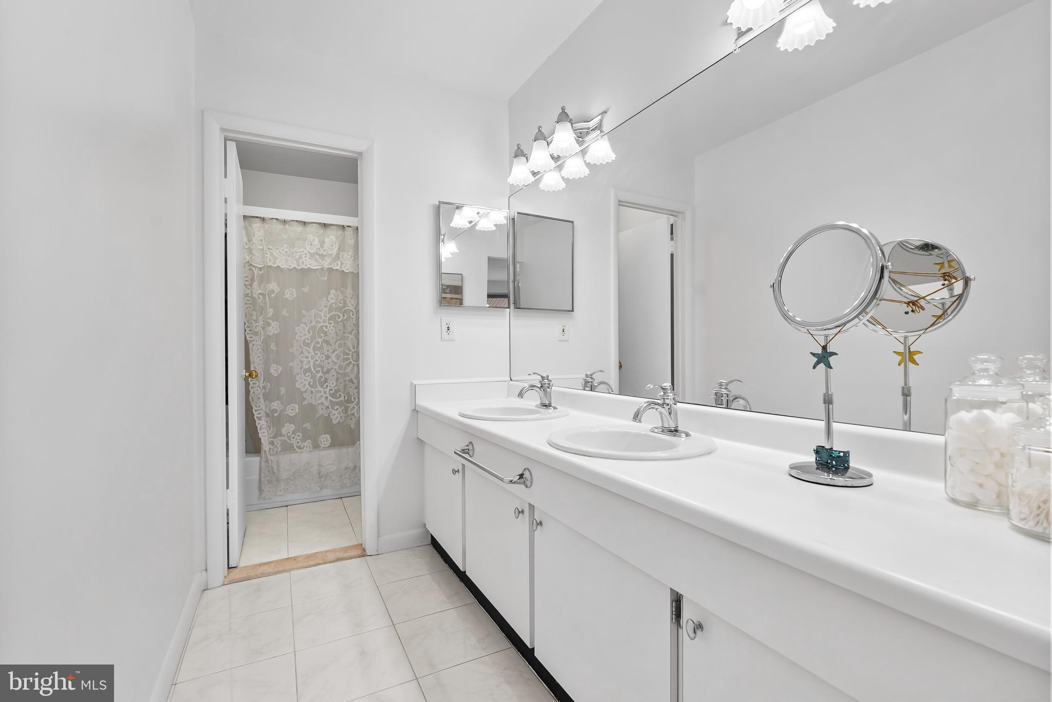 110 Cross Keys Road, Unit F Baltimore, MD 21210 - Photo 11 of 47 a bathroom with a double vanity sink and a mirror