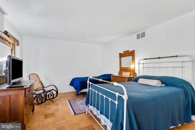 a balcony with table and chairs and potted plants