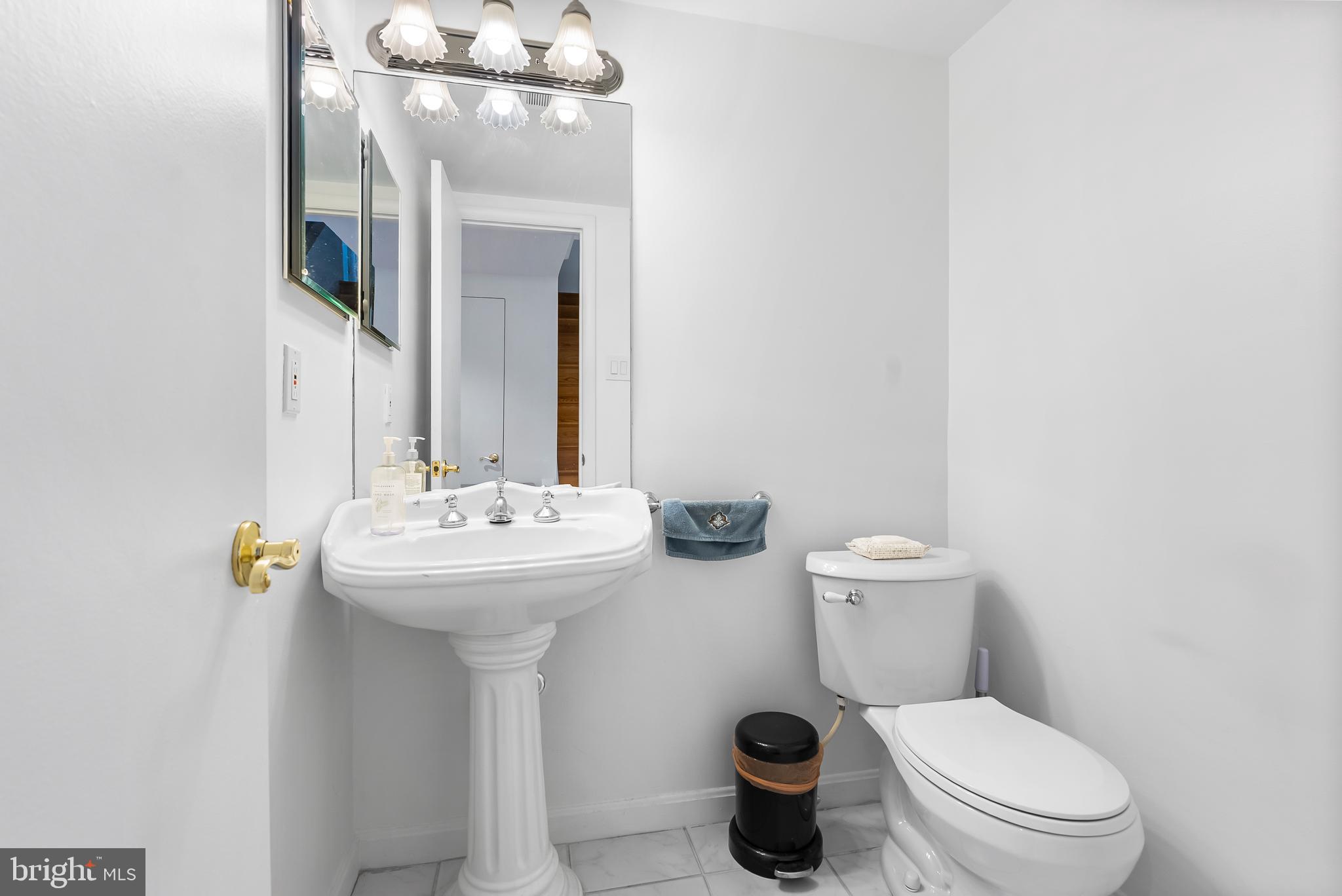 110 Cross Keys Road, Unit F Baltimore, MD 21210 - Photo 10 of 47 a bathroom with a sink a mirror and a toilet