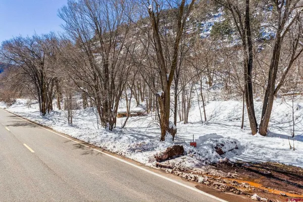 a view of a house with snow on the side of the road