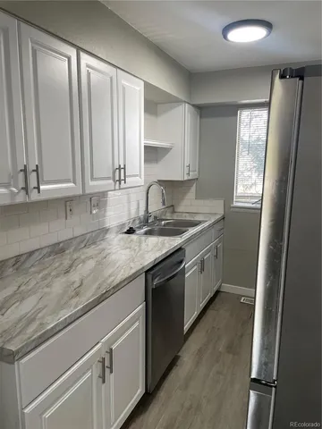 a kitchen with granite countertop white cabinets and white appliances