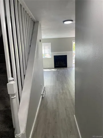 a view of a livingroom with wooden floor and staircase