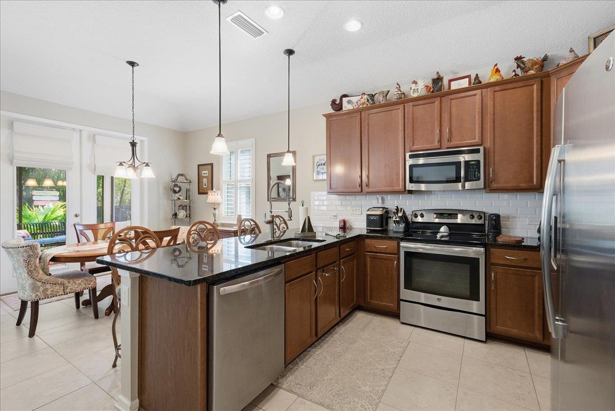 144 Litke Lane St. Augustine, FL 32086 - Photo 12 of 45 a kitchen with stainless steel appliances granite countertop a sink a stove and a refrigerator