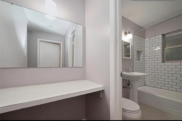 a bathroom with a sink a toilet and mirror