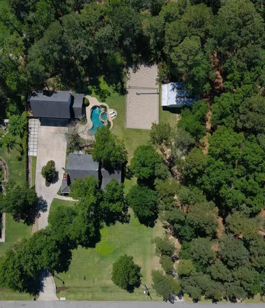 an aerial view of a house with a yard and large trees