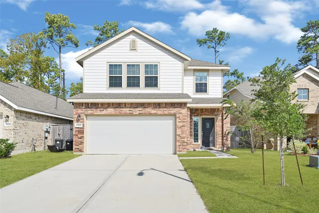 a front view of a house with a yard and garage