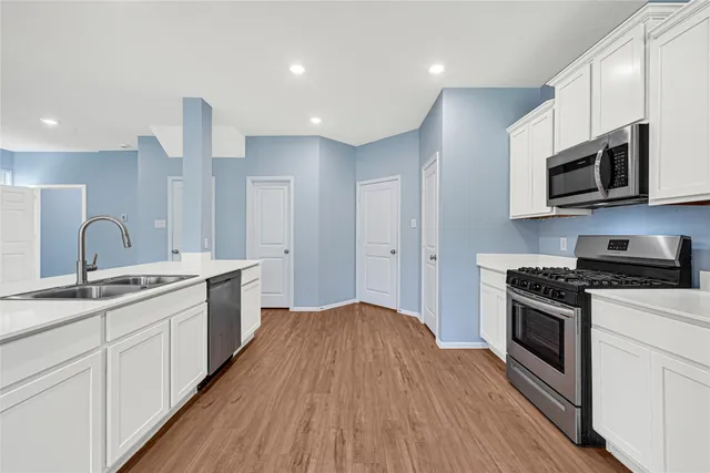 a kitchen with stainless steel appliances granite countertop a stove a sink and a microwave