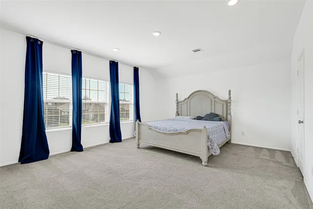 a spacious bedroom with a large bed and a large window