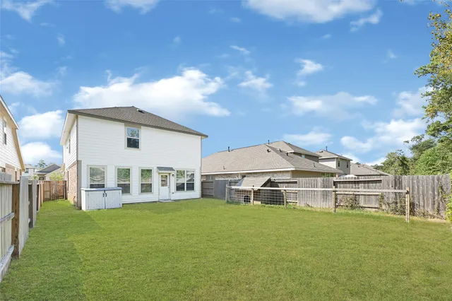 a view of a white house with a big yard and large trees