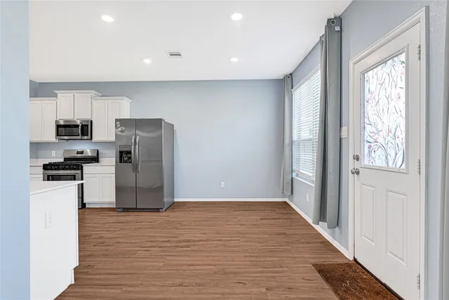 a kitchen with stainless steel appliances a refrigerator and a stove top oven