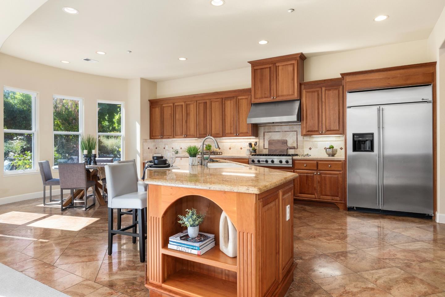 3918 Mainsail Place Soquel, CA 95073 - Photo 9 of 36 a kitchen with stainless steel appliances granite countertop a stove top oven a refrigerator a stove and a dining table with wooden floor