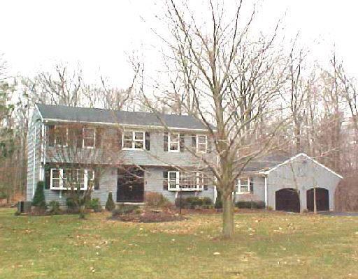 a front view of a house with a yard covered with snow