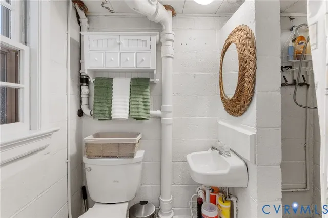 a bathroom with a toilet sink and mirror
