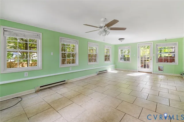 a view of an empty room with window and chandelier fan