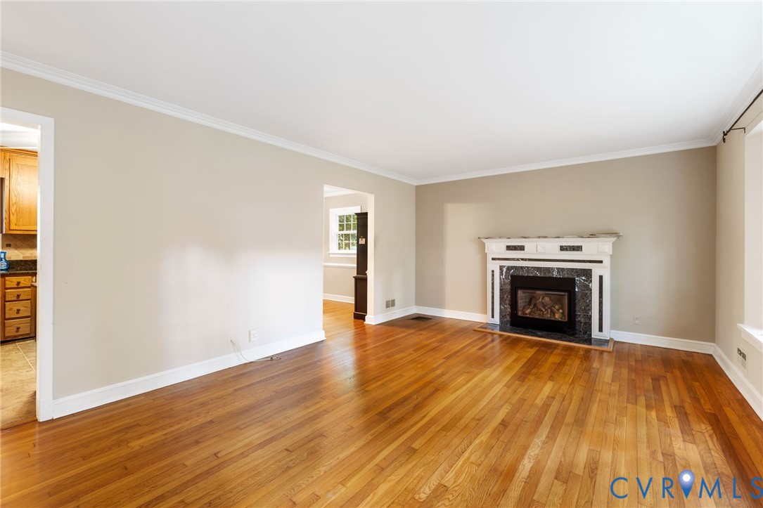 3369 Warner Road Richmond, VA 23225 - Photo 7 of 46 an empty room with wooden floor fireplace and windows