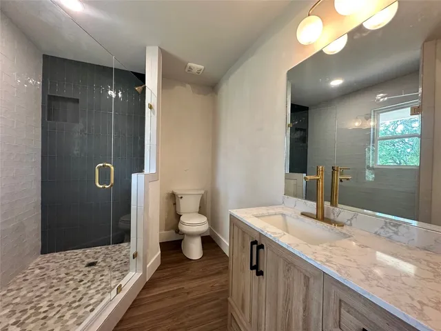 a bathroom with a sink a toilet and shower