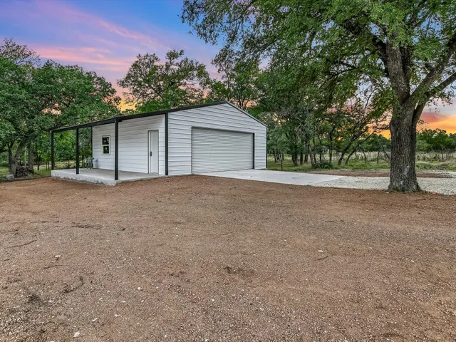 a view of a house with a tree and a yard