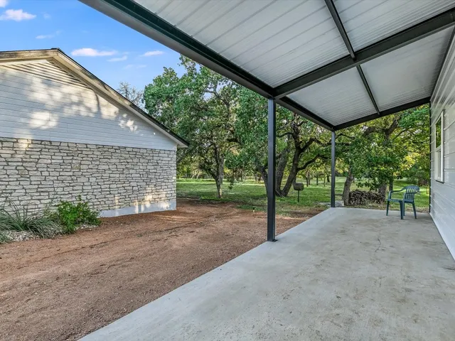 a view of a house with backyard and floor to ceiling window