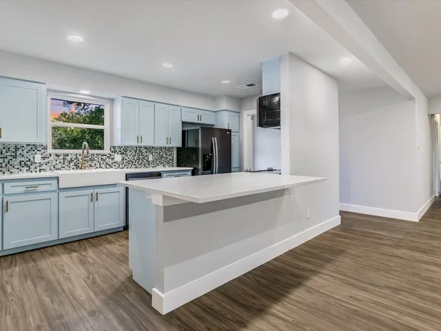 a kitchen with a sink cabinets and wooden floor